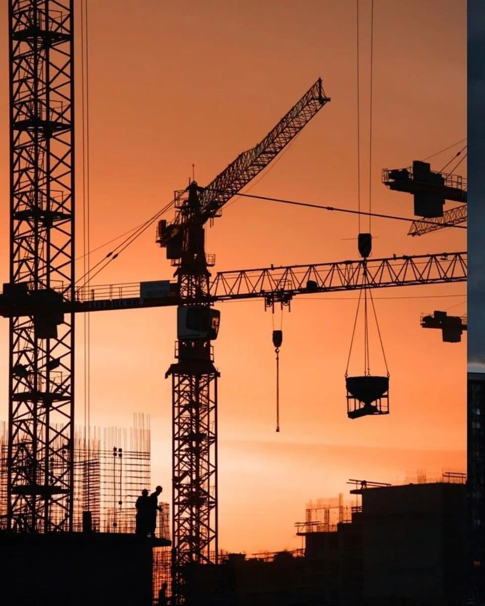 Gruas em obra ao pôr do sol
